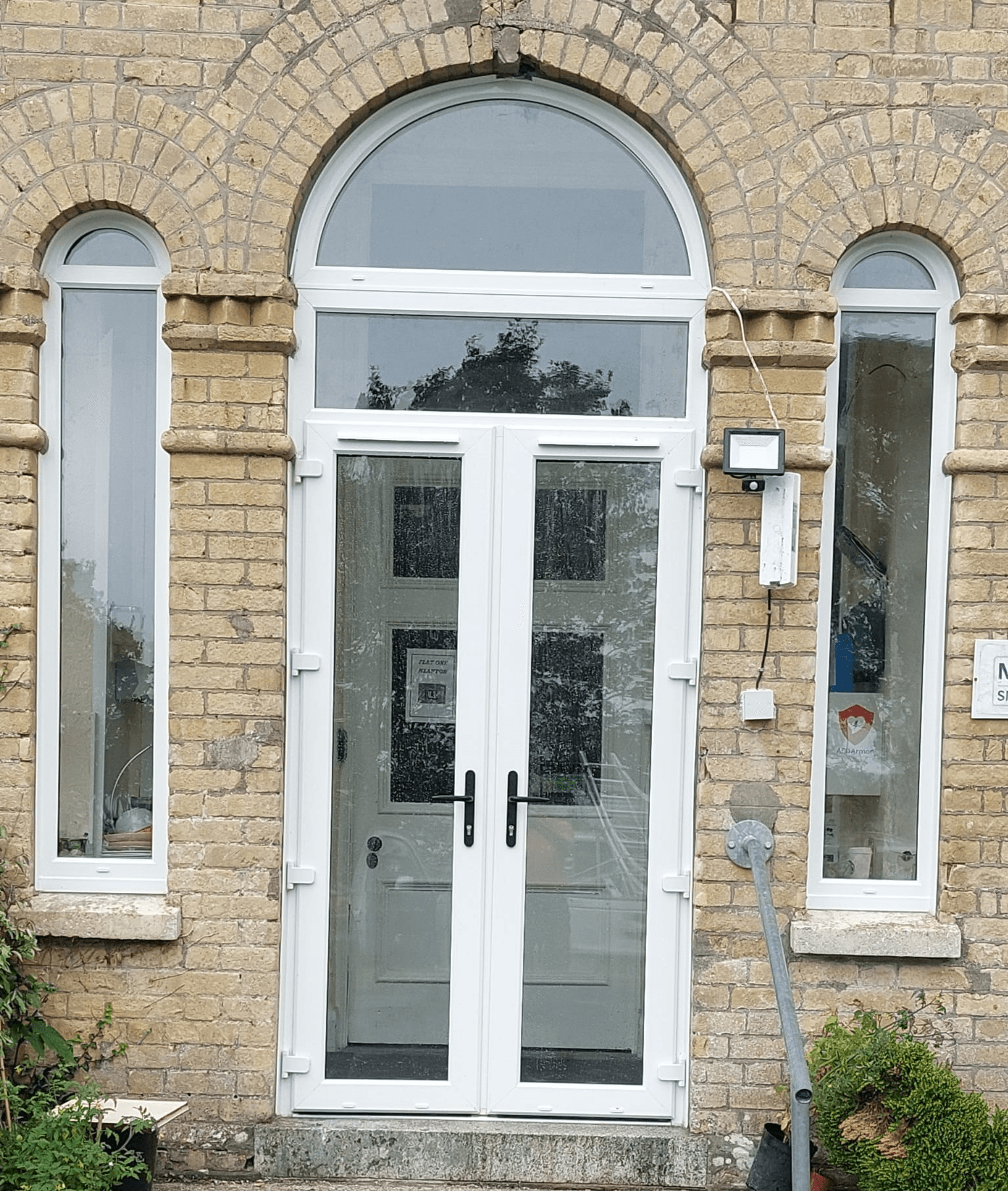 UPVC french doors with arched transom fitted to brick property
